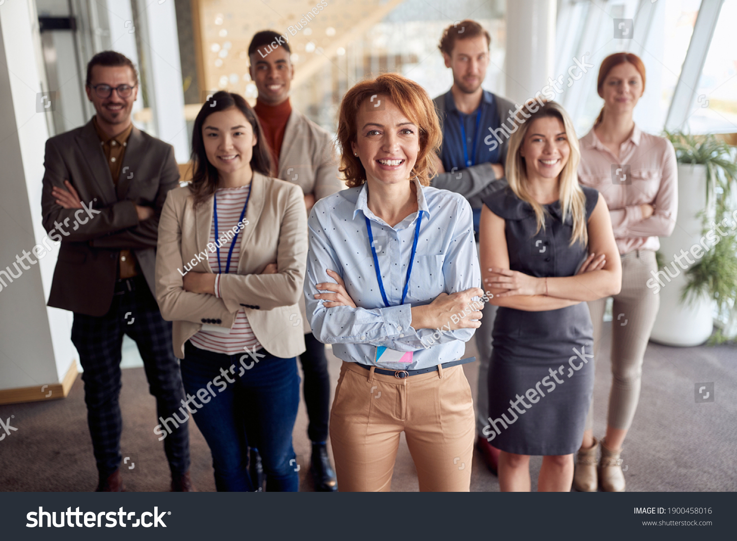 bold and outgoing group of successful business people, looking at camera with team leader in front . eye contact, looking at camera, smiling #1900458016