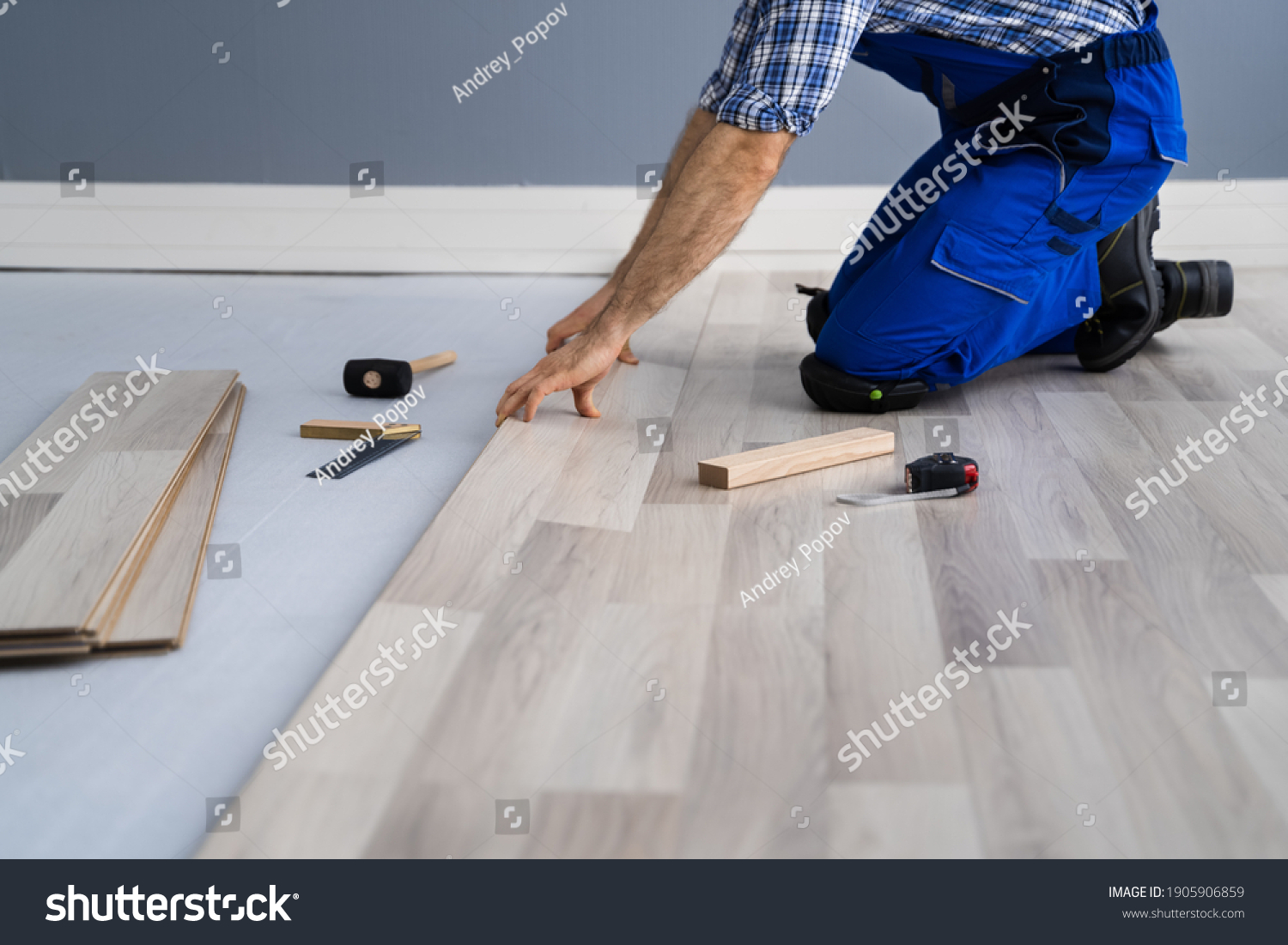Hardwood Floor Renovation. Construction Worker Doing New Laminate Installation #1905906859