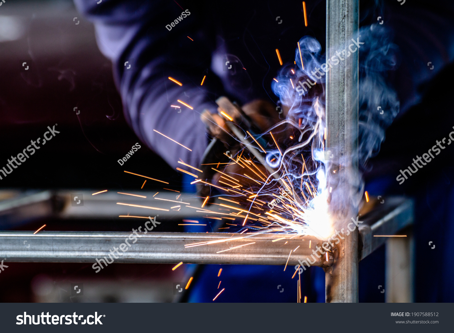 welder and welding sparks, construction and metal work industrial concept, metal welding with sparks, laborer or labor day concept #1907588512