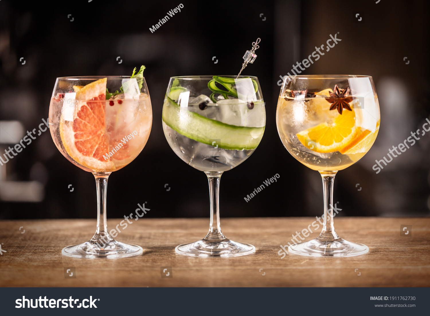 Gin tonic long drink as a classic cocktail in various forms with garnish in individual glasses such as orange, grapefruit, or cucumber. #1911762730