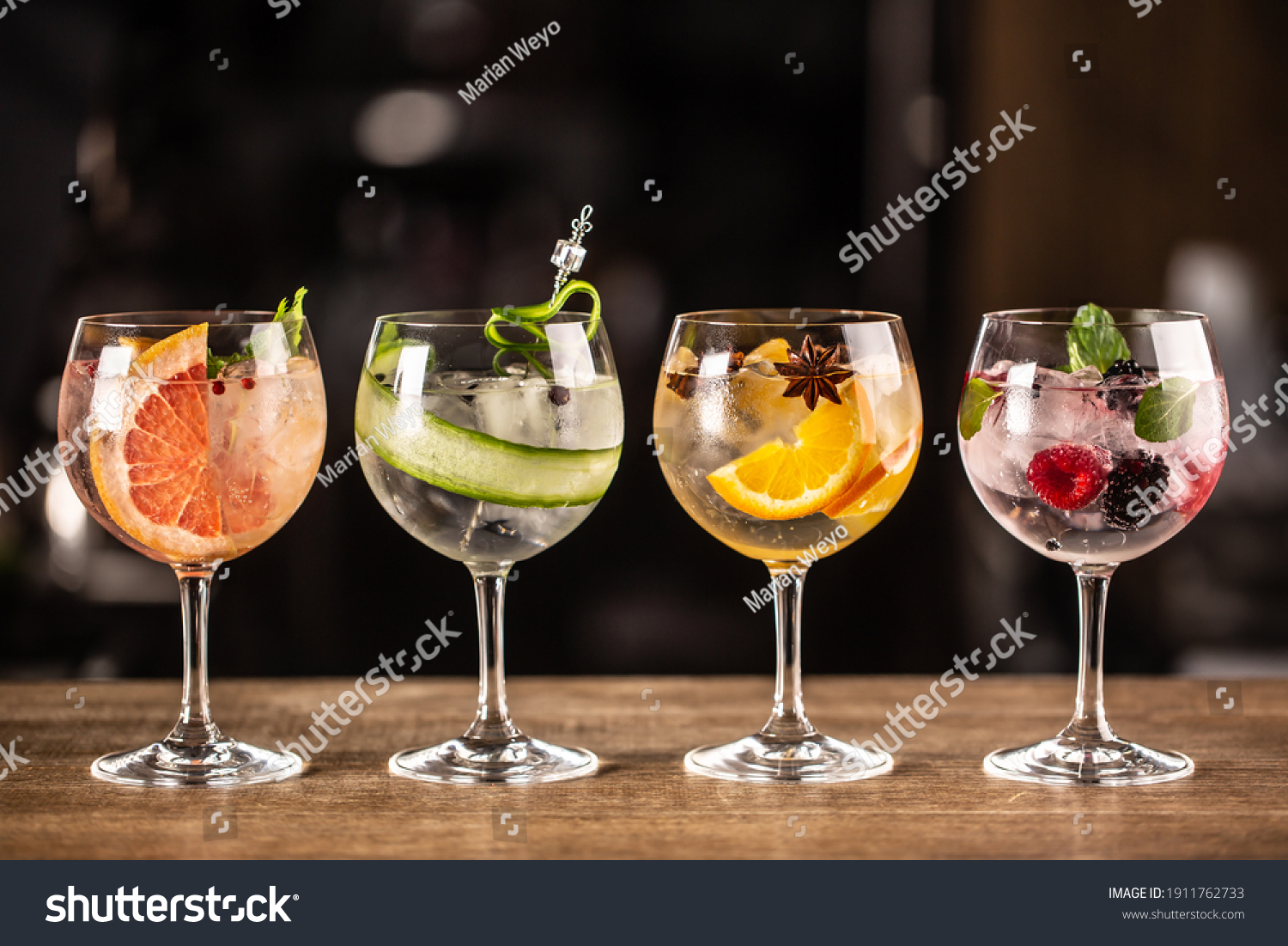 Gin tonic long drink as a classic cocktail in various forms with garnish in individual glasses such as orange, grapefruit, cucumber or berries. #1911762733