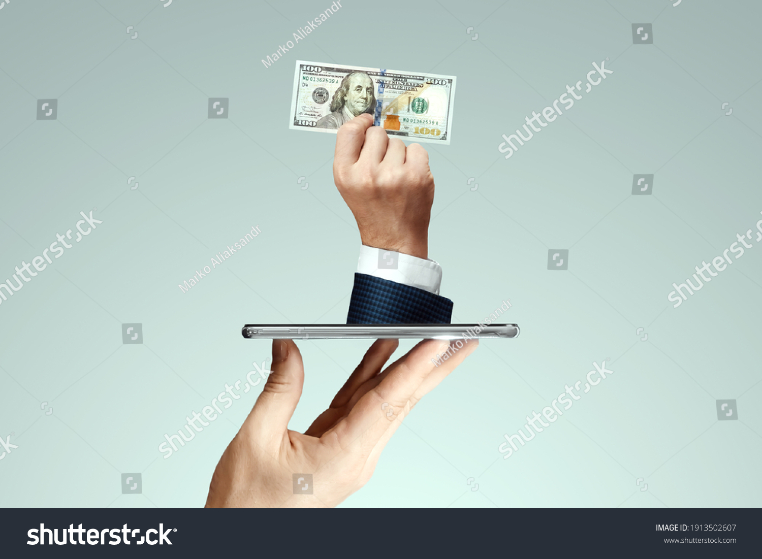 A businessman's hand crawls out of the smartphone screen with a one hundred dollar bill. Concept of money transfers, internet banking work online #1913502607