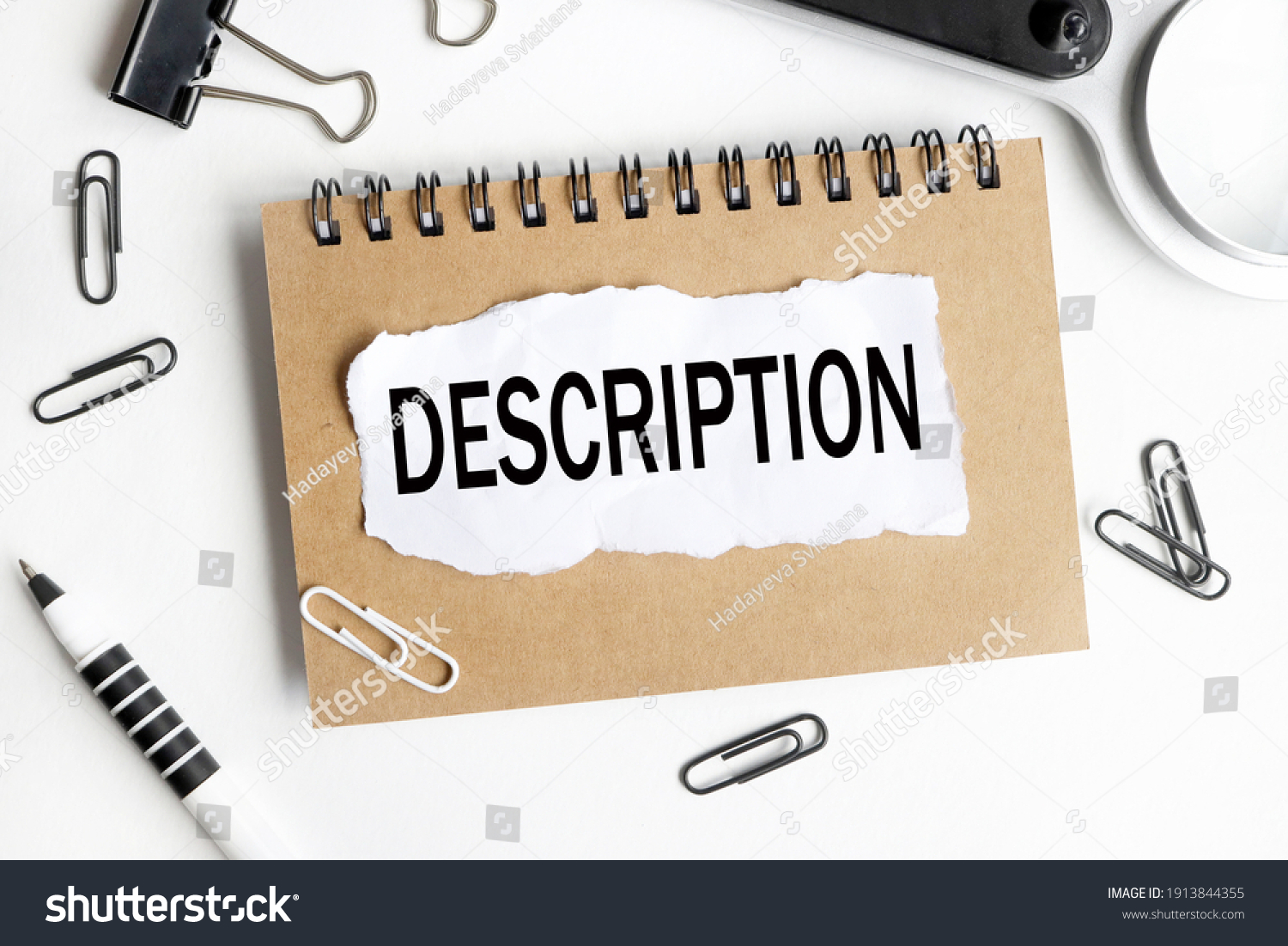 DESCRIPTION. text on white paper over white background. notebook, pen. #1913844355