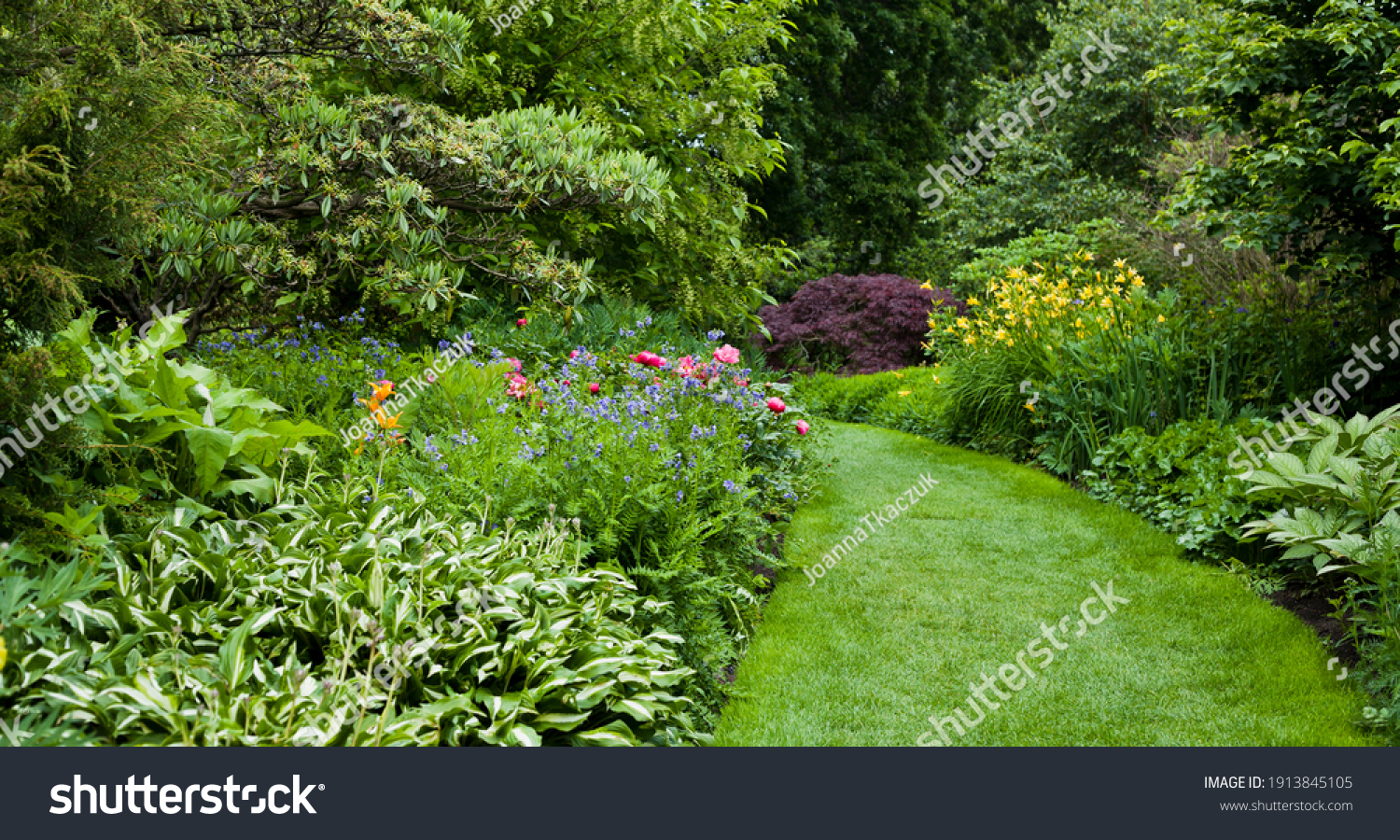 Lush green botanical garden - blooming spring flowers and lawn path. #1913845105