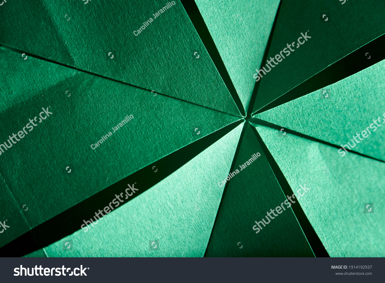 Abstract radial green background of folded textured paper. Close-up image. Concepts: origami, color, lines and geometry. #1914192937