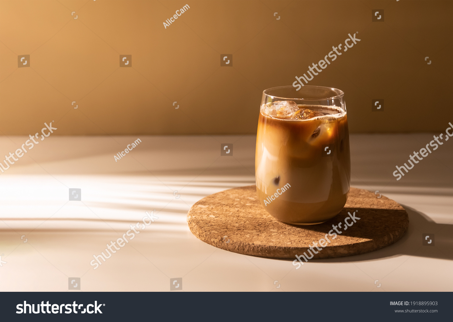 Glass of a iced coffee with cream milk. Cold brew coffee drink with ice. Early morning sun light. Copy space. #1918895903