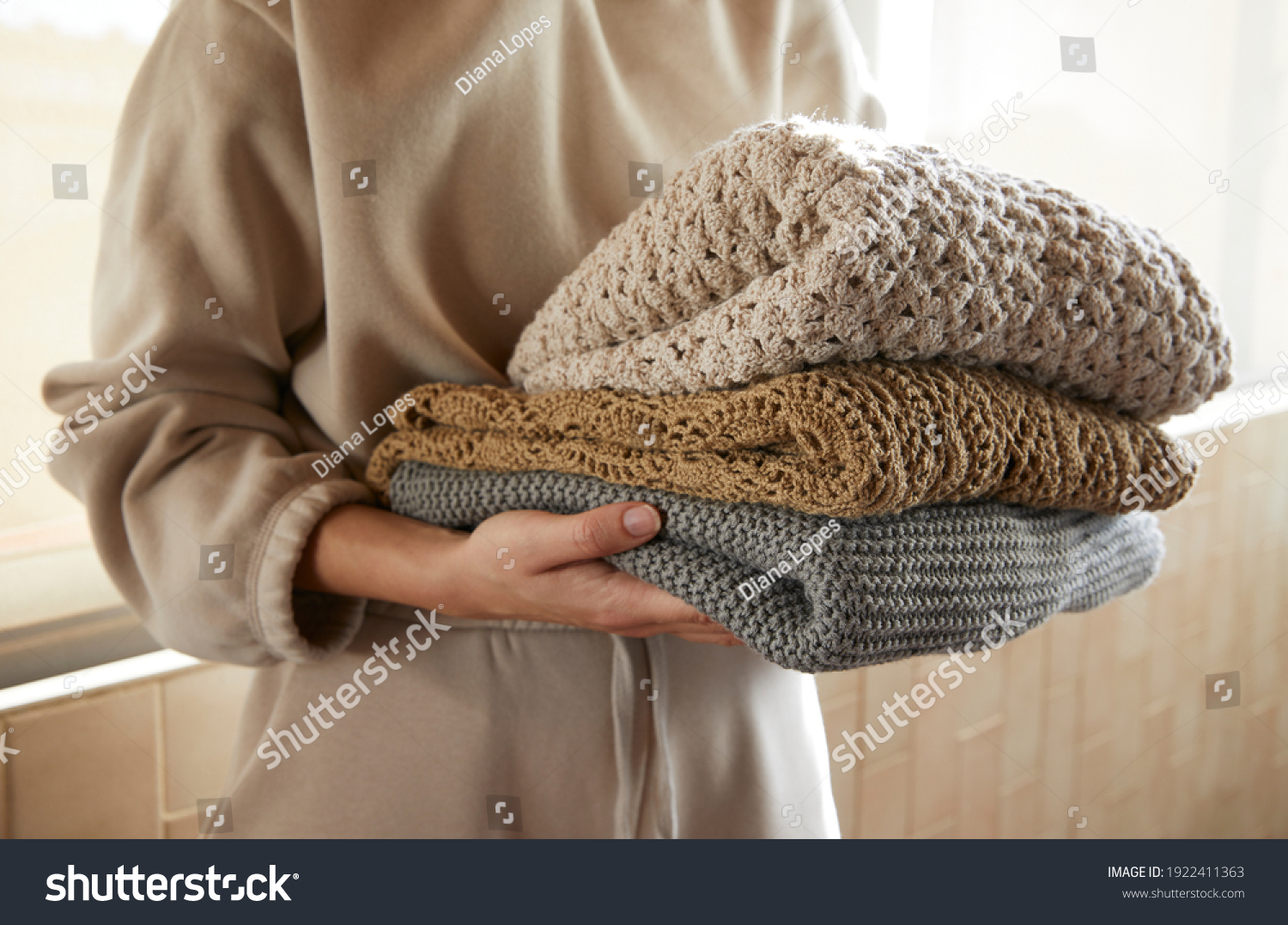 Hand holding a stack of sustainable cloths in tracksuit, homemade and Eco friendly fabric #1922411363