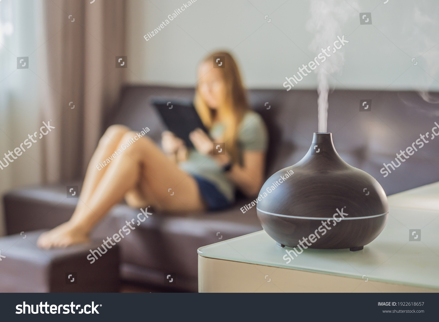 Aromatherapy Concept. Wooden Electric Ultrasonic Essential Oil Aroma Diffuser and Humidifier. Ultrasonic aroma diffuser for home. Woman resting at home #1922618657