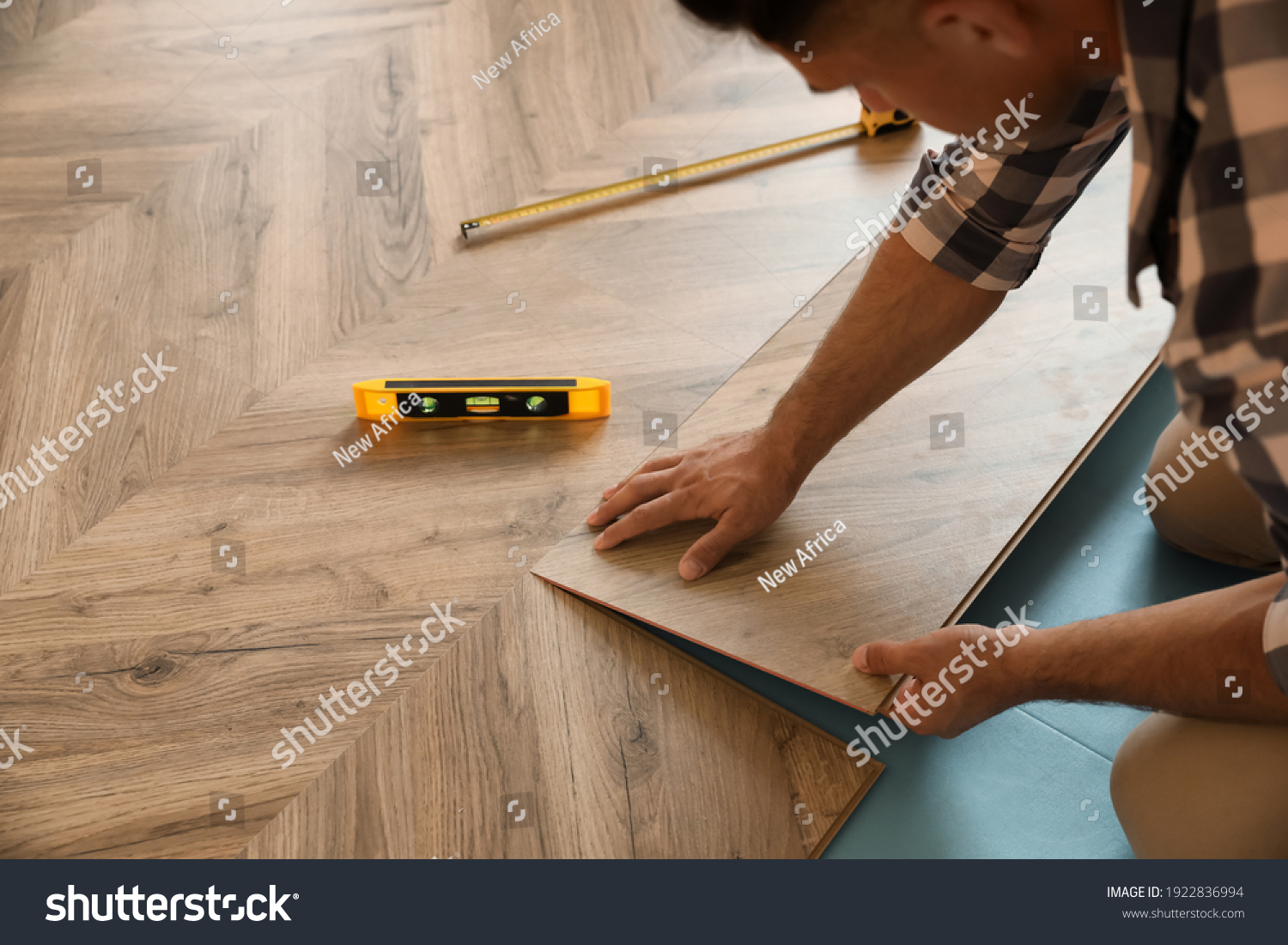 Professional worker installing new parquet flooring indoors, closeup #1922836994