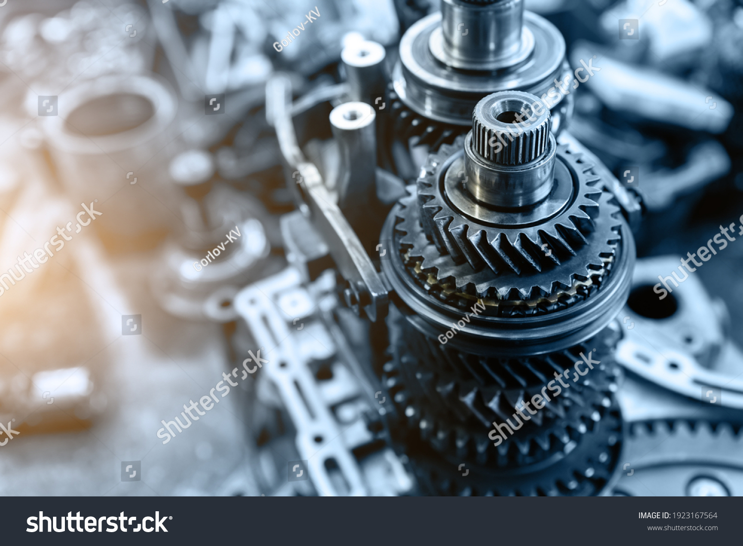 Closeup disassembled car automatic transmission gear part on workbench at garage or repair factory station for fix service or maintenance. Vehicle part detail. Complex industrial mechanism background #1923167564