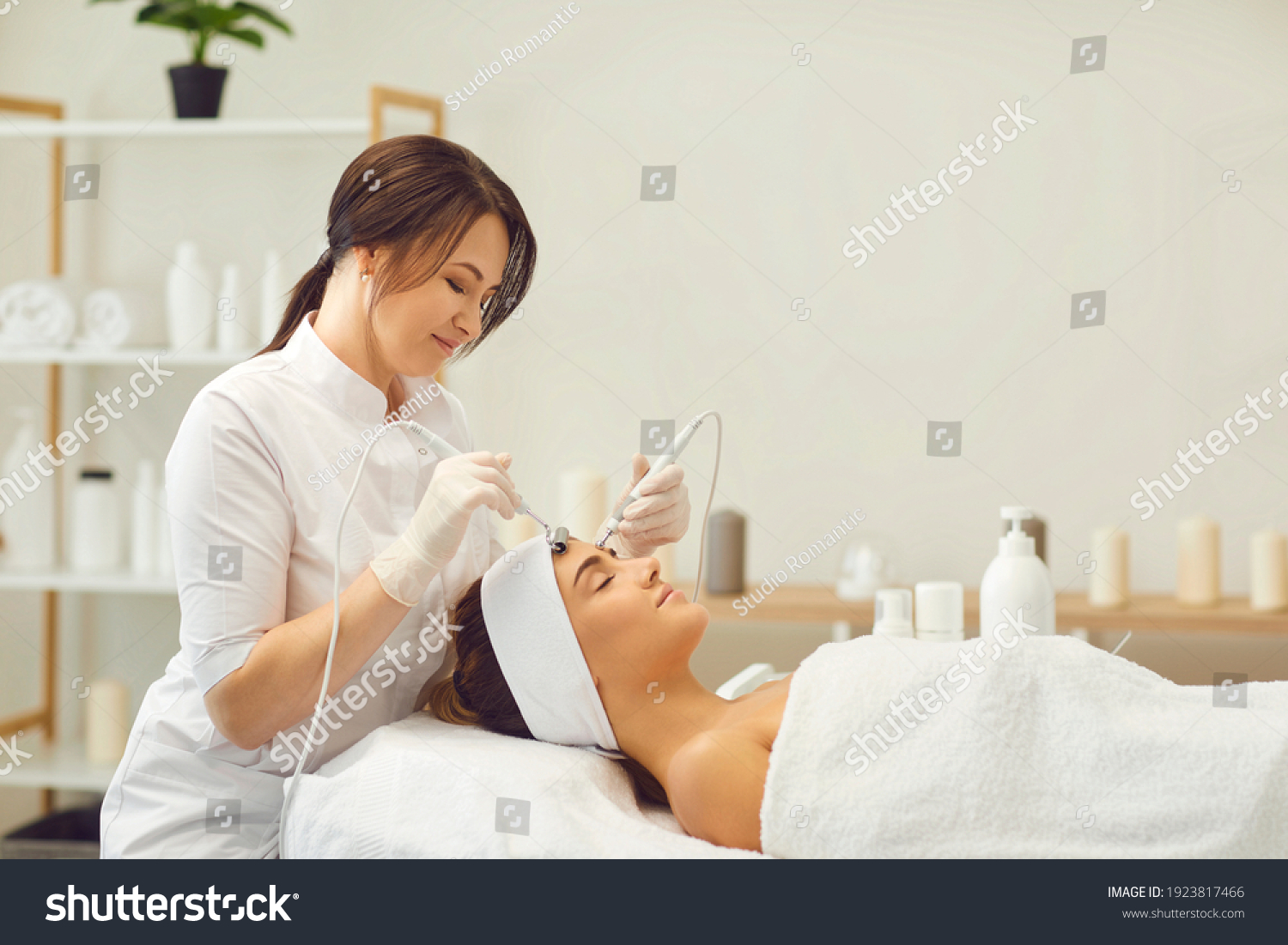Beautician makes a young beautiful girl a vacuum facial treatment for rejuvenation. Girl is undergoing a course of spa treatments in the office of a beautician. #1923817466