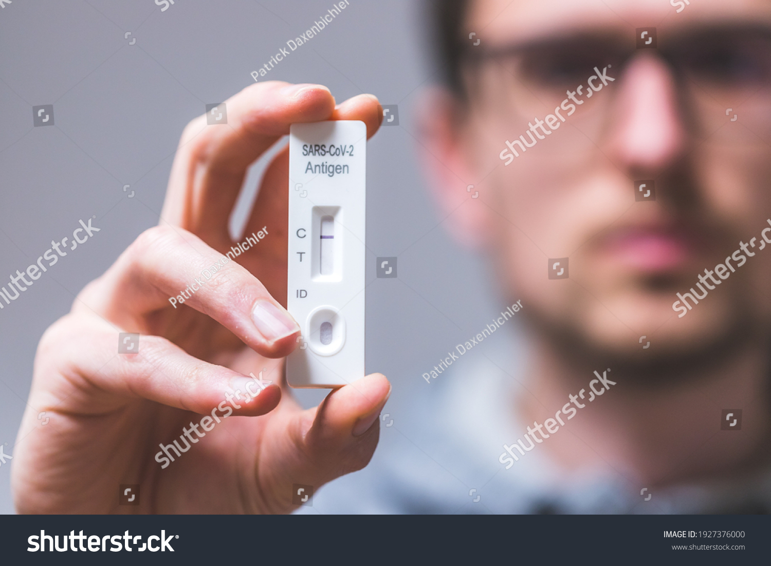 Close up of young man holding express antigen covid test, negative result #1927376000