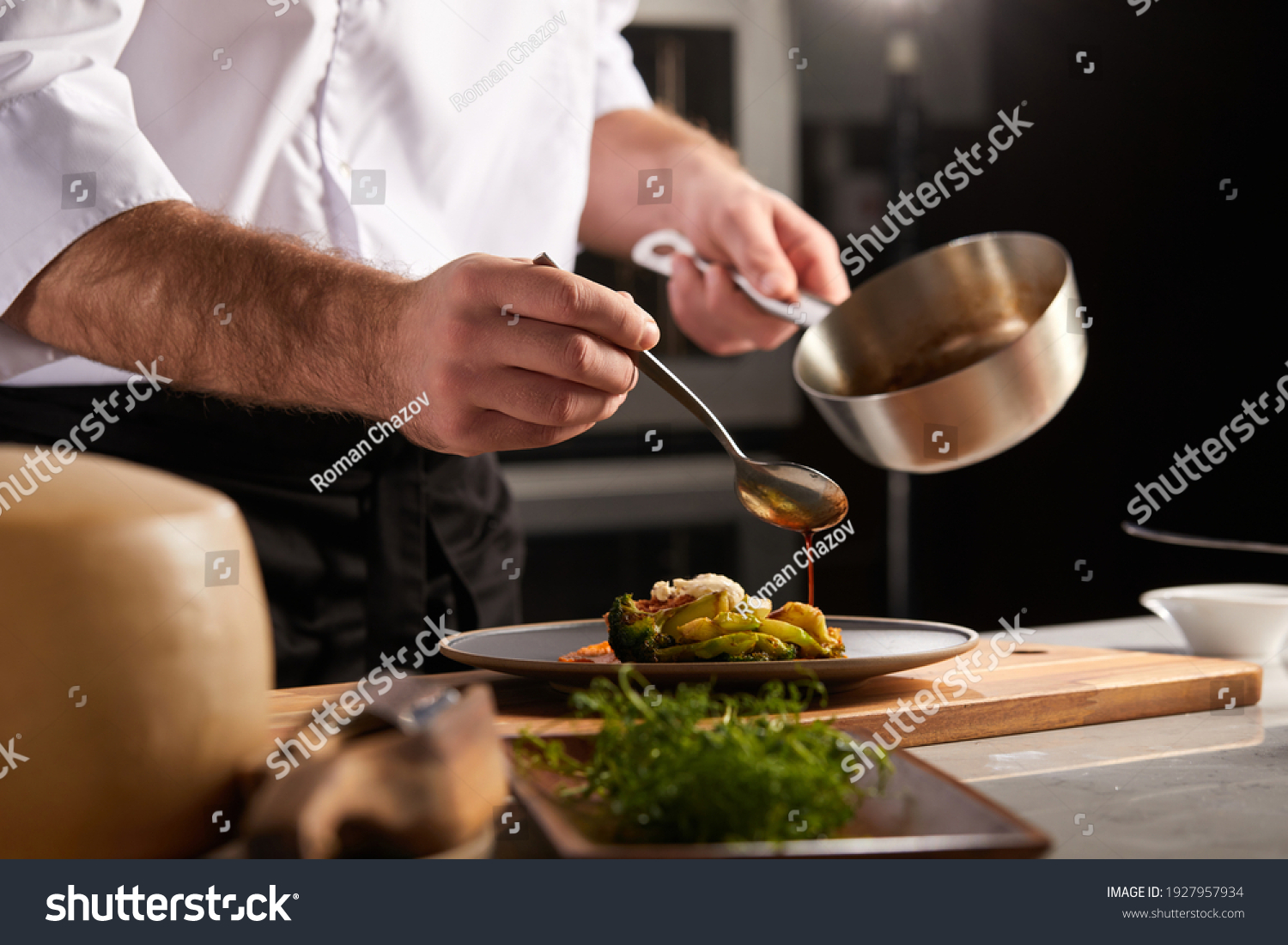 Professional cook in uniform add some spices to dish, decorating delicious meal for guests in hotel restaurant. food, cooking concept #1927957934