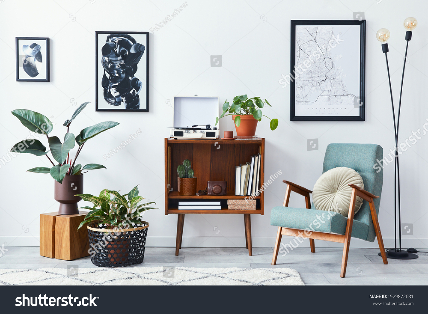 Modern retro composition of living room interior with design wooden cabinet, stylish armchair, mock up poster map, plants, vinyl recorder, books and personal accessories in home decor. Template. #1929872681