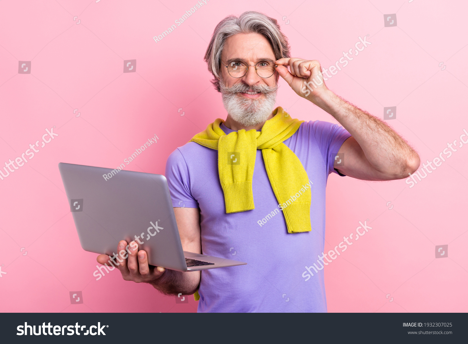 Portrait of attractive cheery skilled gray-haired man holding on palm using laptop touching specs isolated on pink pastel color background #1932307025