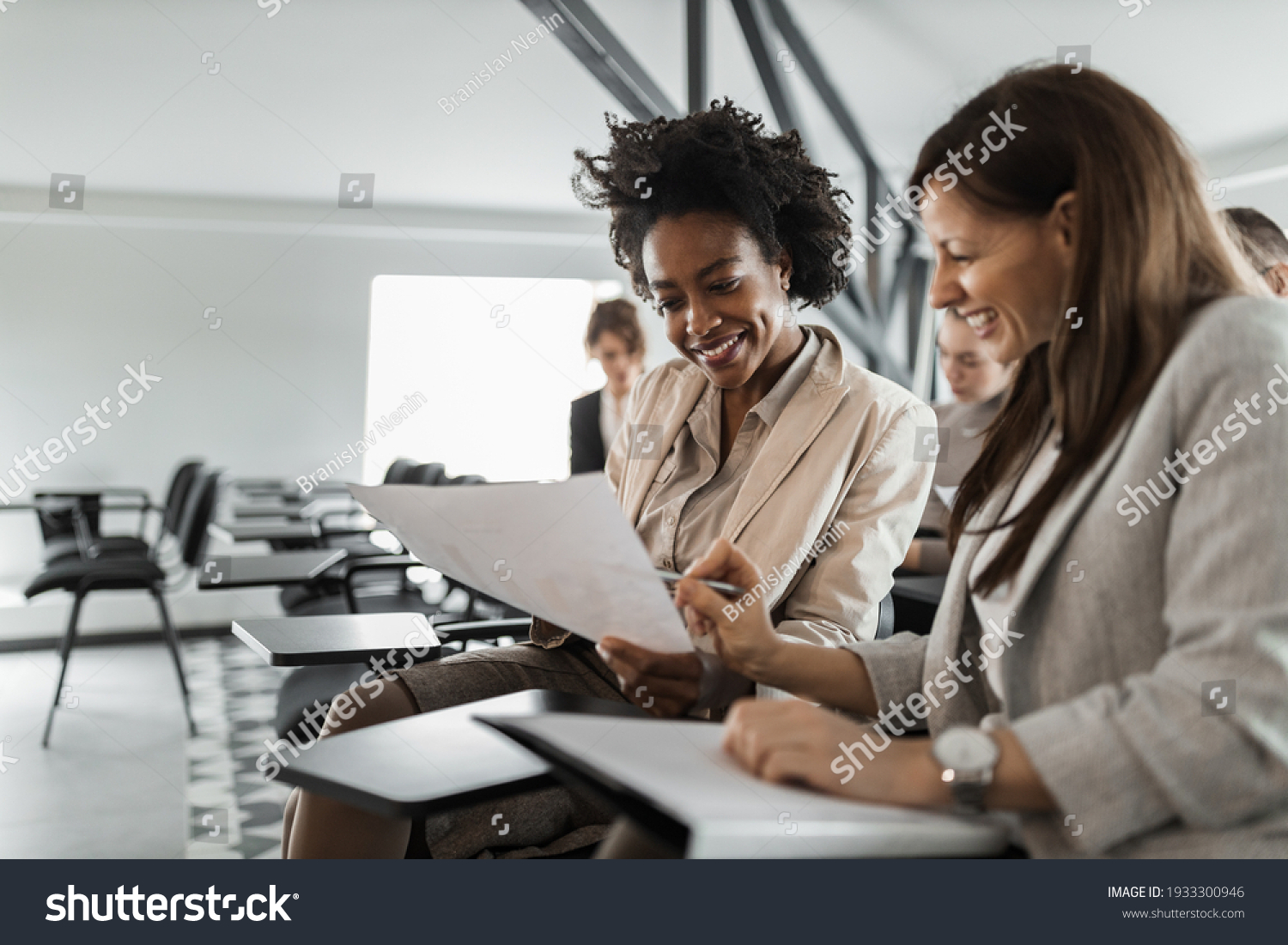 Two females in a suits, doing paper work. #1933300946