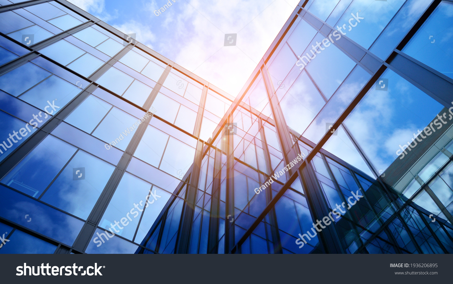 Modern office building with glass facade on a clear sky background. Transparent glass wall of office building. #1936206895