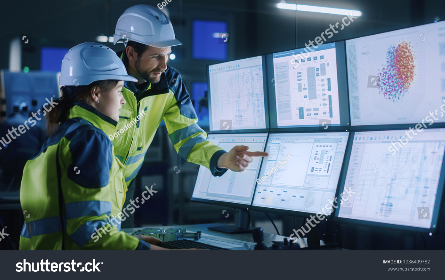 Industry 4.0 Modern Factory: Chief Project Manager Talks to Female Engineer, She Points at Computer Screens Showing Complex Industrial Electronics Design Blueprints, They Have Find Problem Solution #1936499782