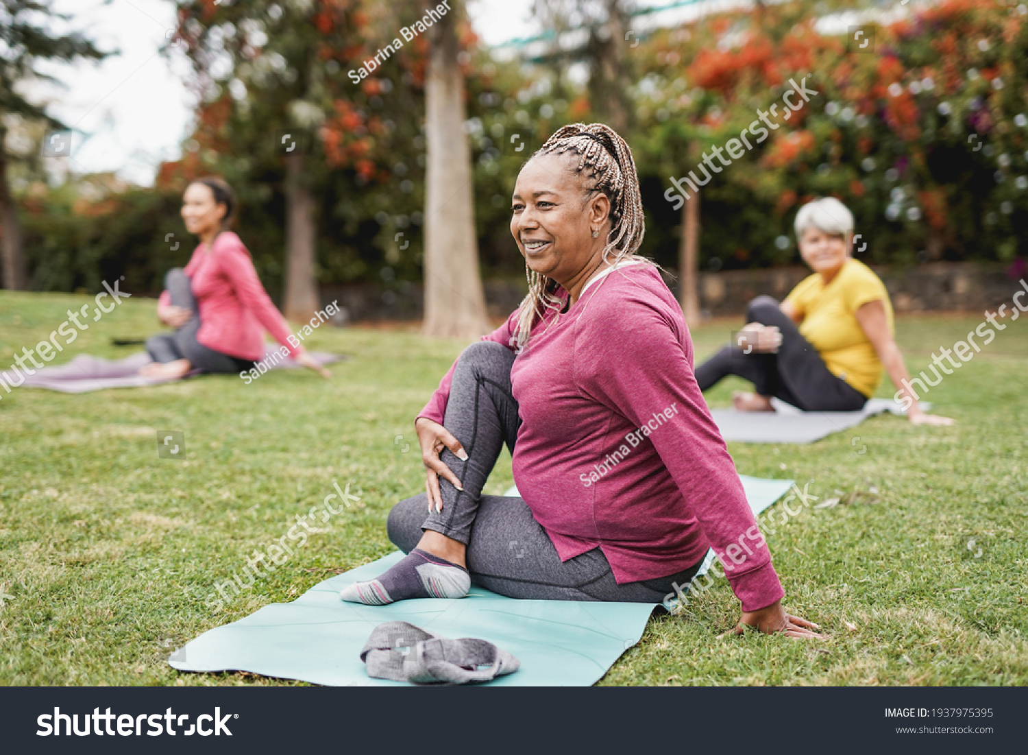 Multiracial women doing yoga exercise with social distance for coronavirus outbreak at park outdoor - Healthy lifestyle and sport concept #1937975395