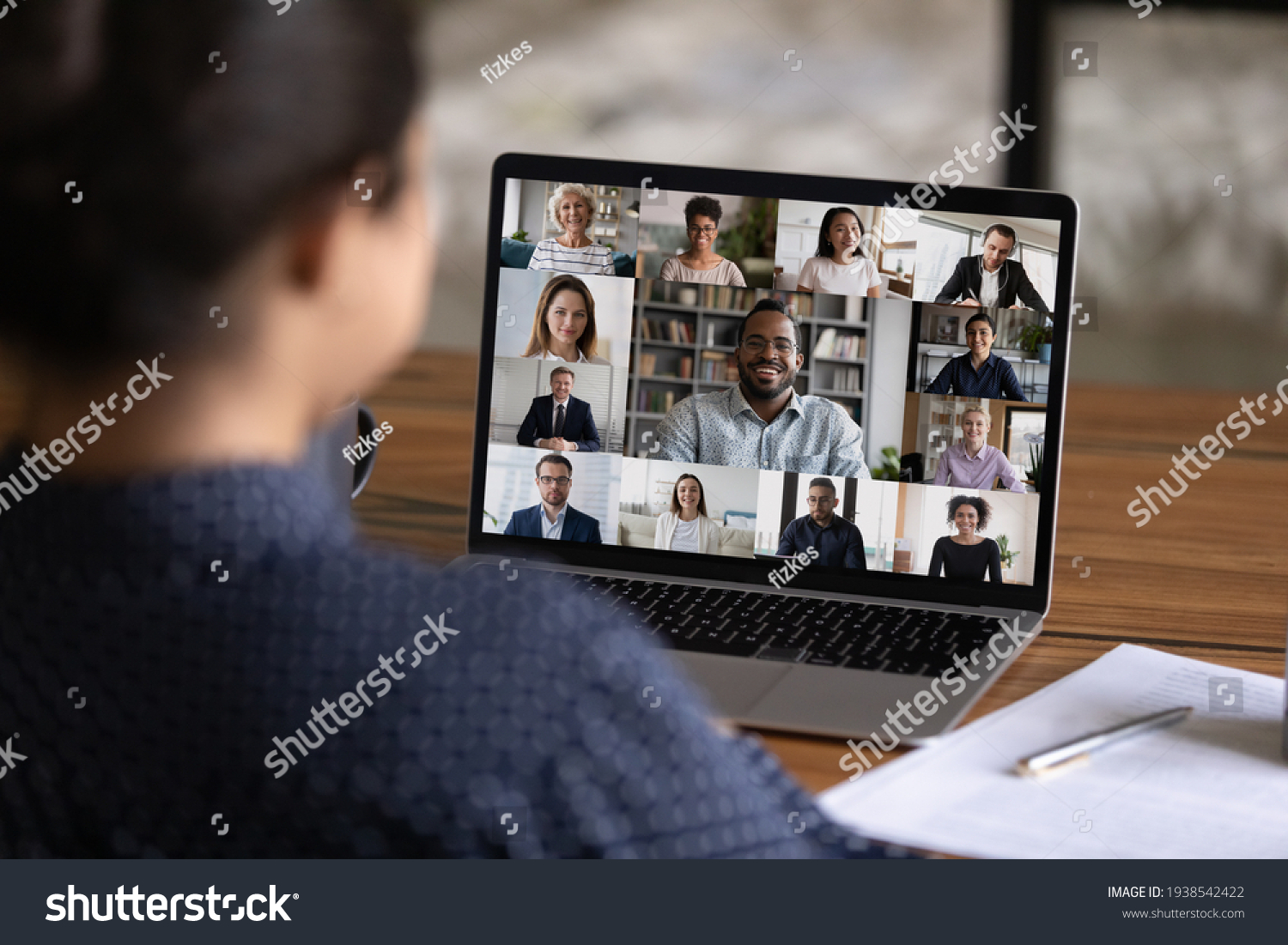 Over shoulder view of female worker have webcam digital virtual conference with diverse multiethnic colleagues. Woman speak talk on video call with multiracial businesspeople. Online meeting concept. #1938542422
