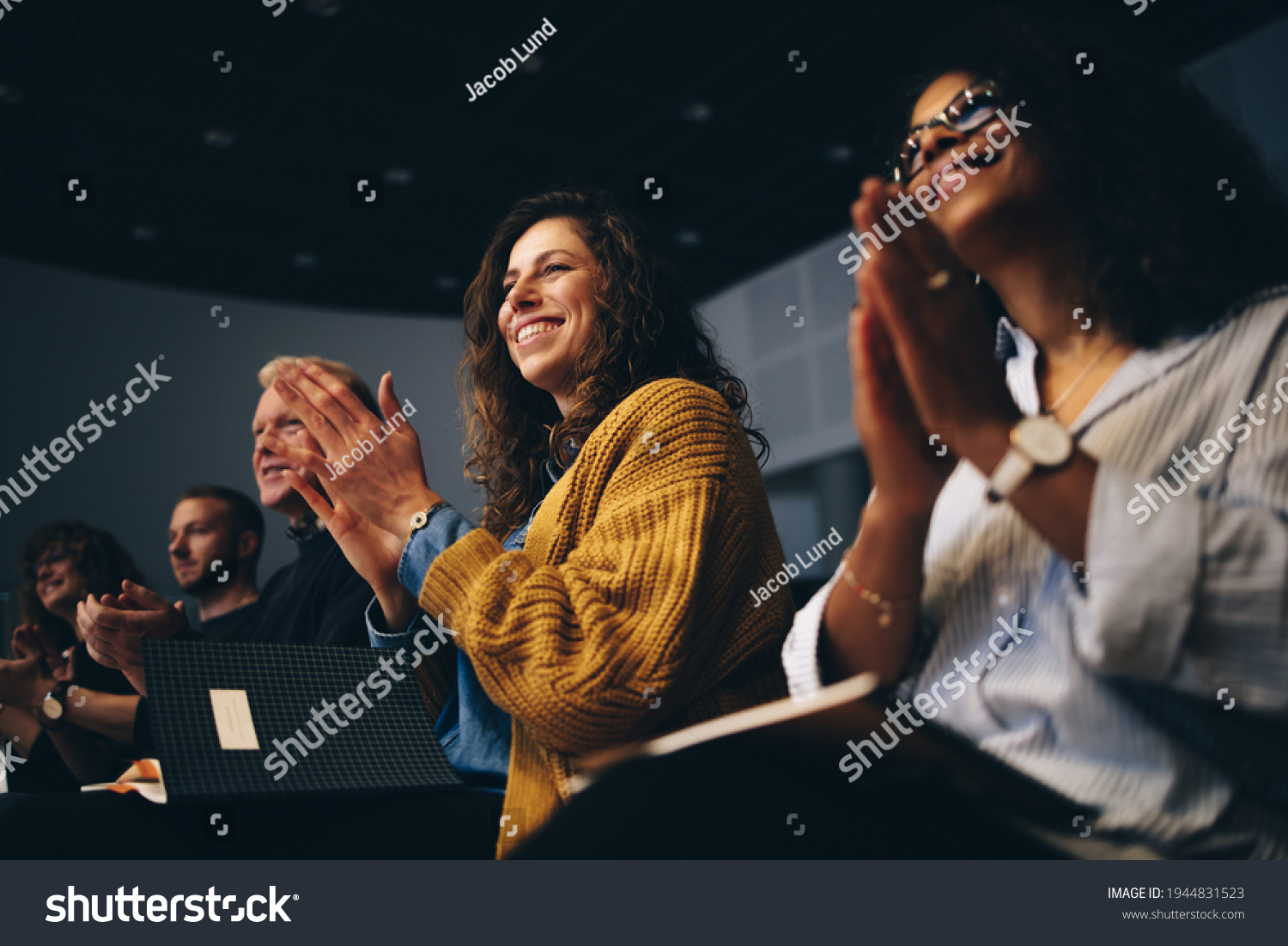 Audience listening to the speech and clapping hands. Group of business people attending a convention applauding during the forum. #1944831523