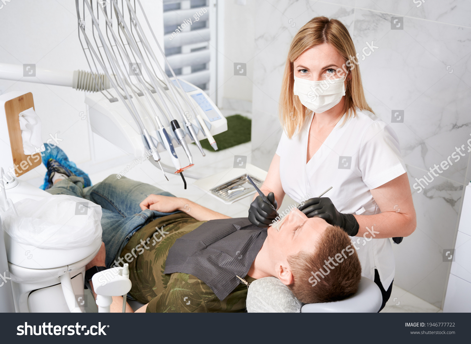 Young man receiving orthodontic treatment in dental office. #1946777722