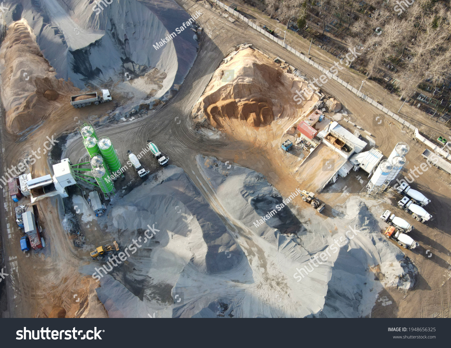 Ready mix concrete batching plant. Producing сoncrete and portland cement mortar for construction and formworks. Pouring concrete through to a ready-mixed truck. Drone view. Out of focus #1948656325