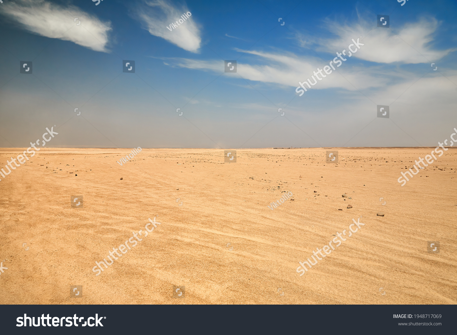 Dry desert landscape. Hot lifeless sand of desert and blue sky in summer sunny day. Flat desert of Egypt. Travel and tourism concept. #1948717069