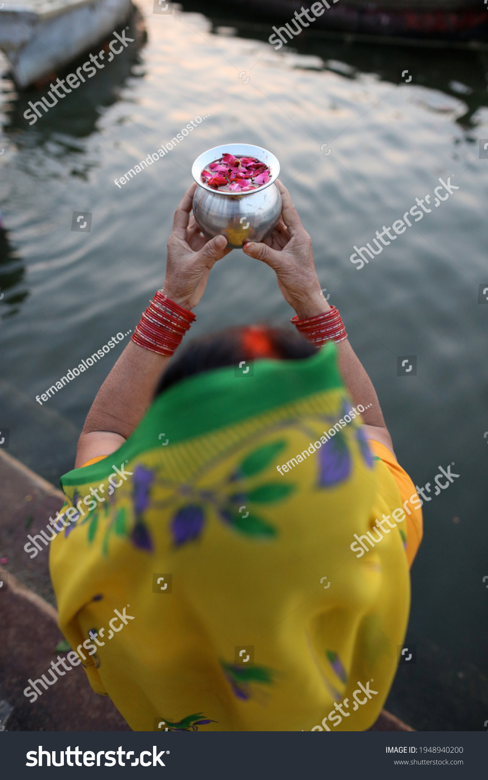 woman offering prayers to ancestors in Ganges river, India #1948940200