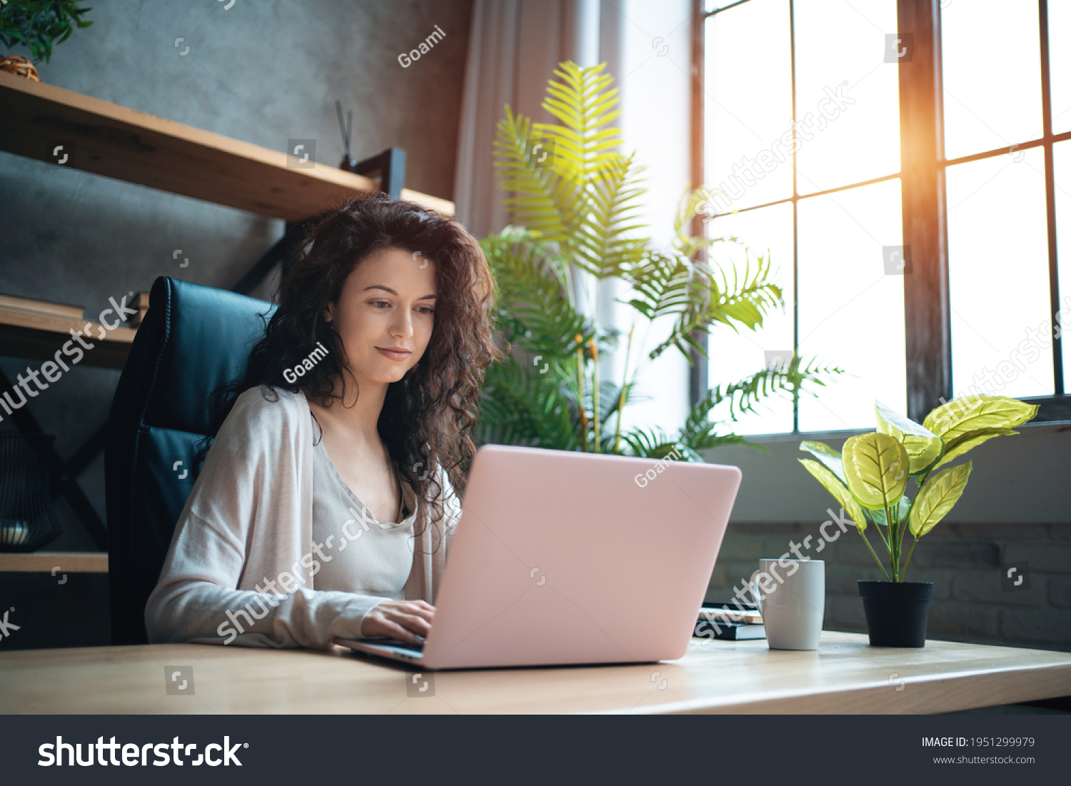 cheerful female manager working with laptop and typing at home office #1951299979