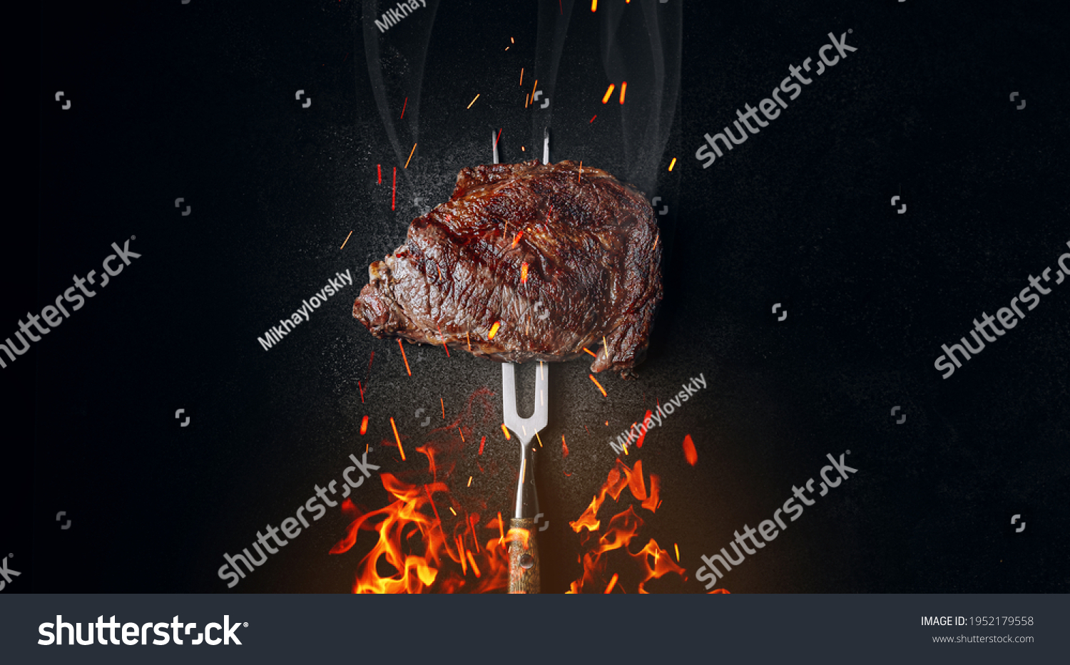 medium rare steak on an iron fork on a dark background. from below, fire and sparks. meat and fire. #1952179558