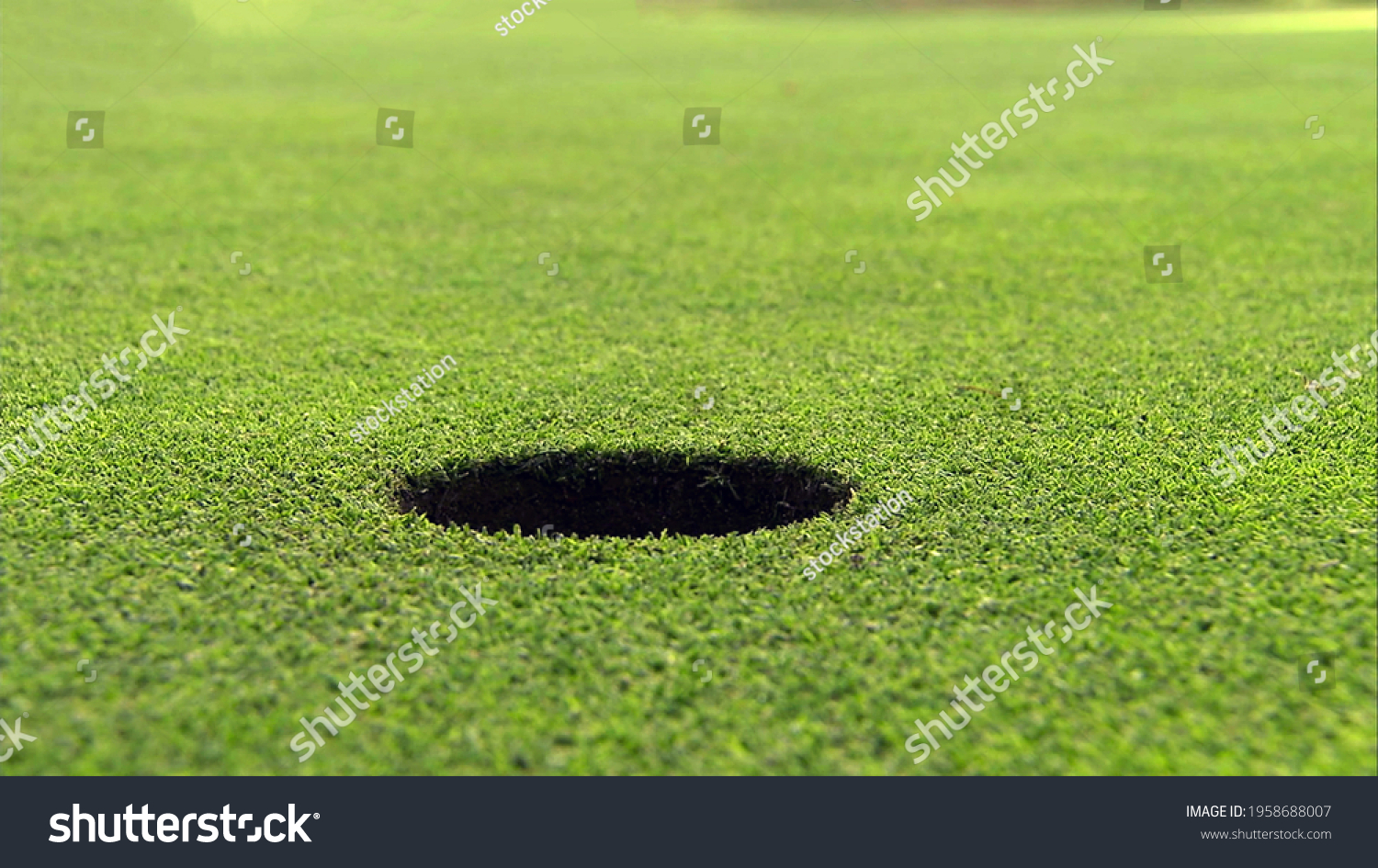 A hole on the golf course in close up view with green grass ground background. #1958688007