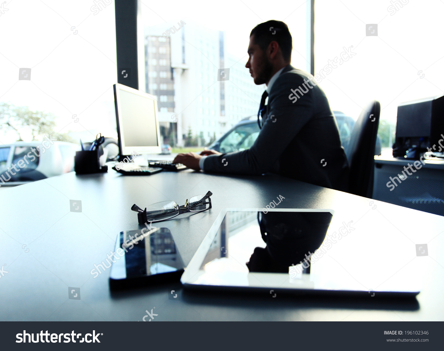 Silhouette of businessman using laptop in office  #196102346