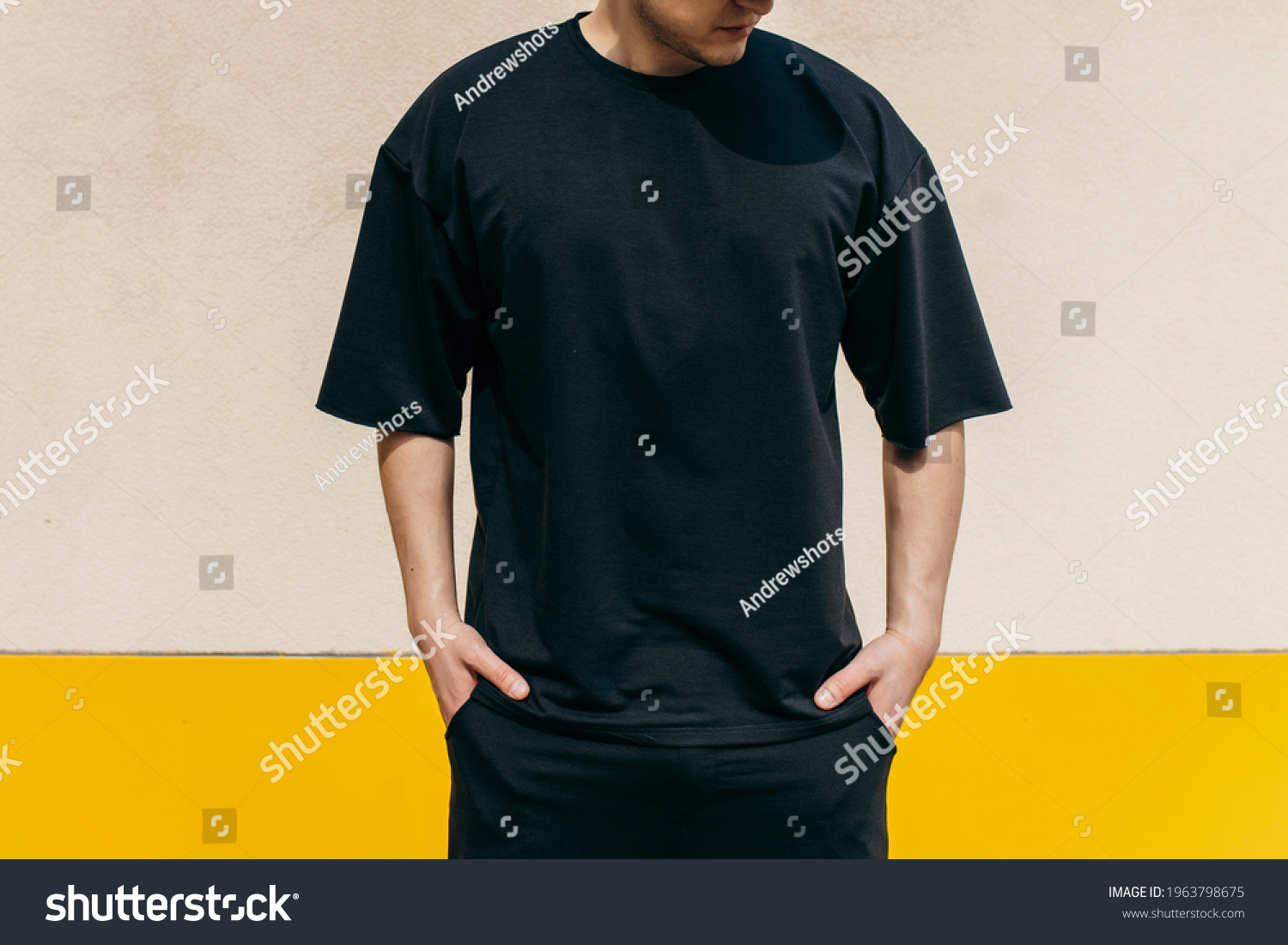 Man wearing black blank t-shirt with space for your logo or design. Mock up #1963798675