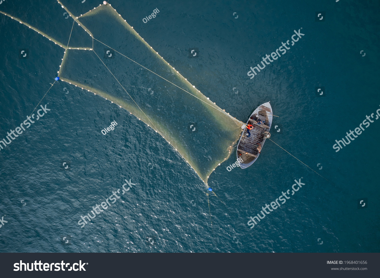 Vintage wooden boat in coral sea. Boat drone photo. A fisherman on a fishing boat is casting a net for catching fish. #1968401656