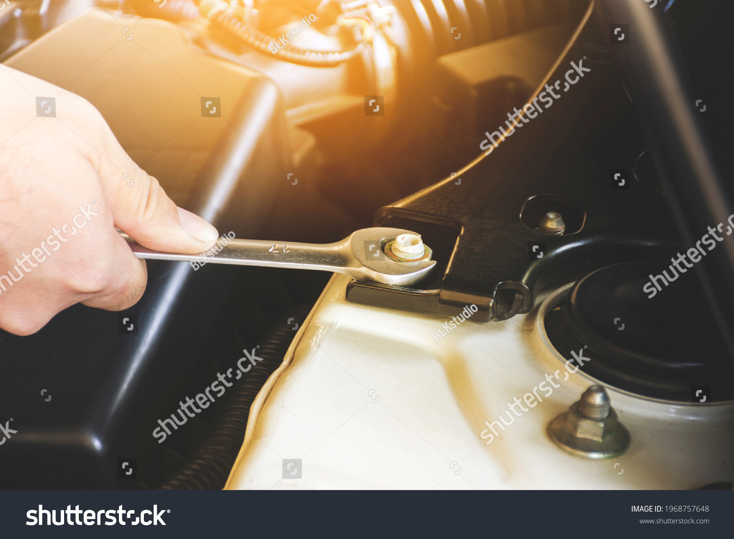 Mechanic hand is unscrewing the metal nut with a combination wrench spanner #1968757648