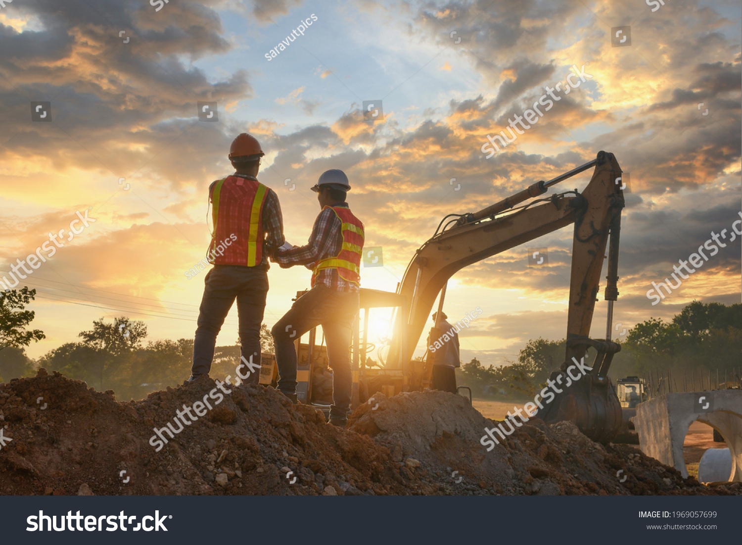 Construction engineers supervising progress of construction project stand on new factory,Engineering Consulting People on construction site holding blueprint in his hand. Building inspector.  #1969057699