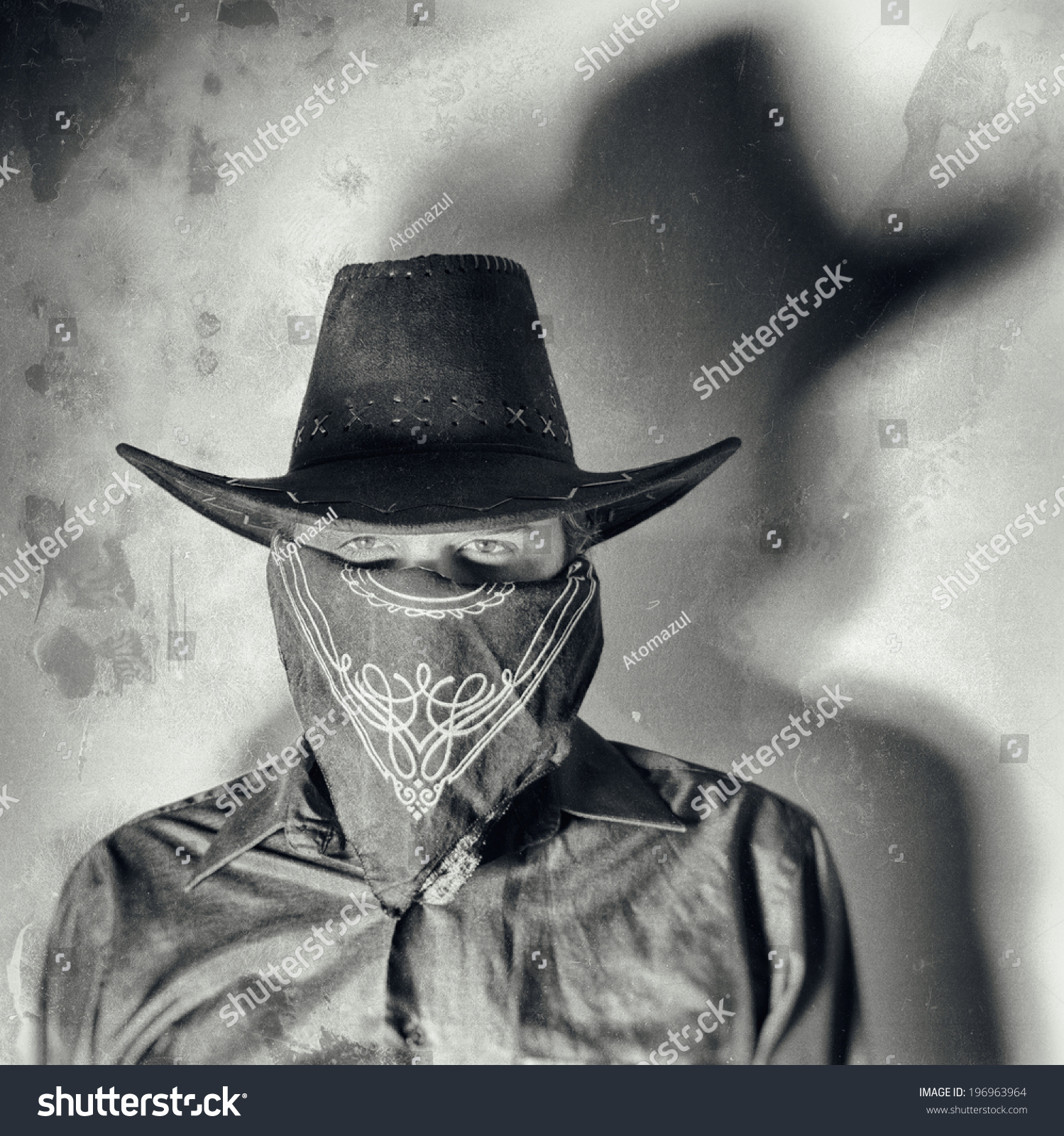 Old West Bandit. Old west bandit outlaw with covered face and cowboy hat, edited in vintage film style. #196963964