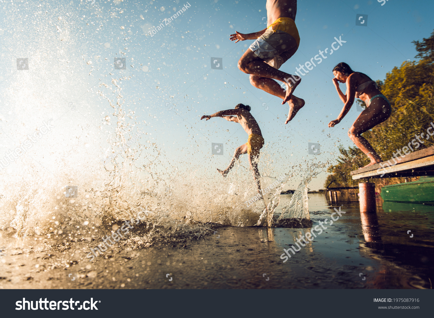 Friends having fun enjoying a summer day swimming and jumping at the lake. #1975087916