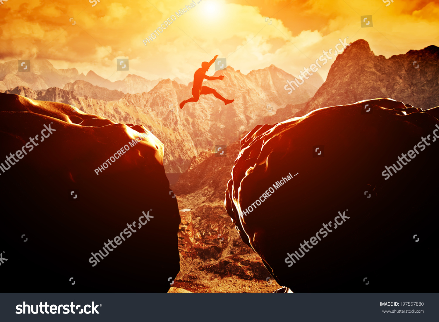 Man jumping over precipice between two rocky mountains at sunset. Freedom, risk, challenge, success. #197557880