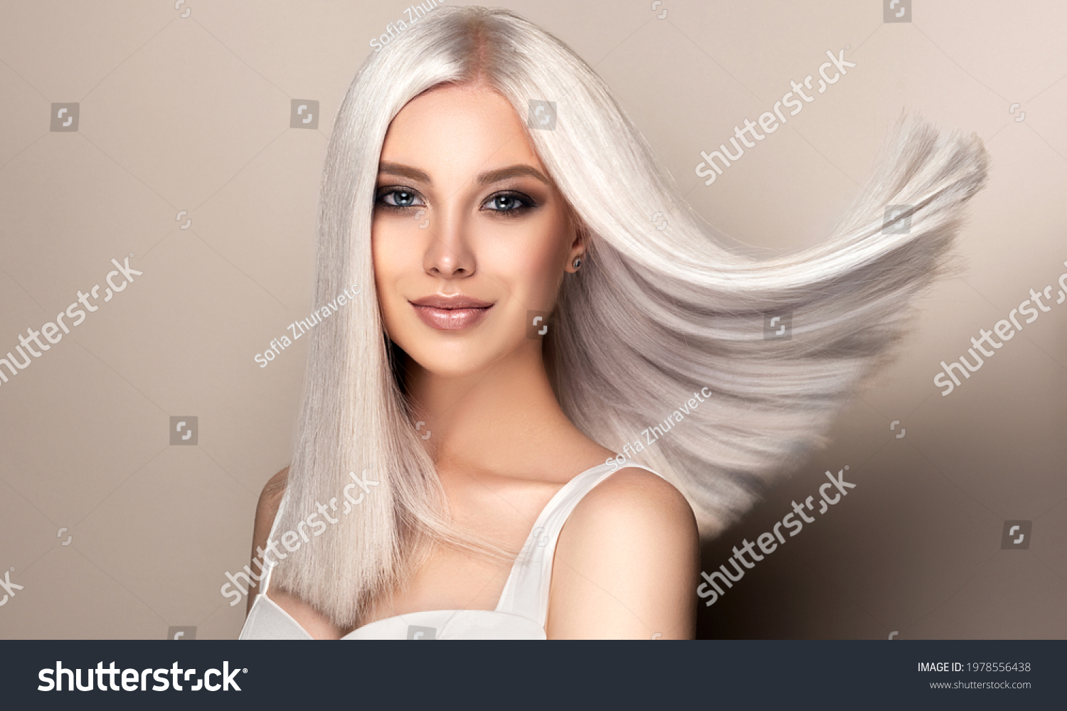 Beautiful girl with hair coloring in ultra blond. Stylish hairstyle done in a beauty salon. Fashion, cosmetics and makeup #1978556438