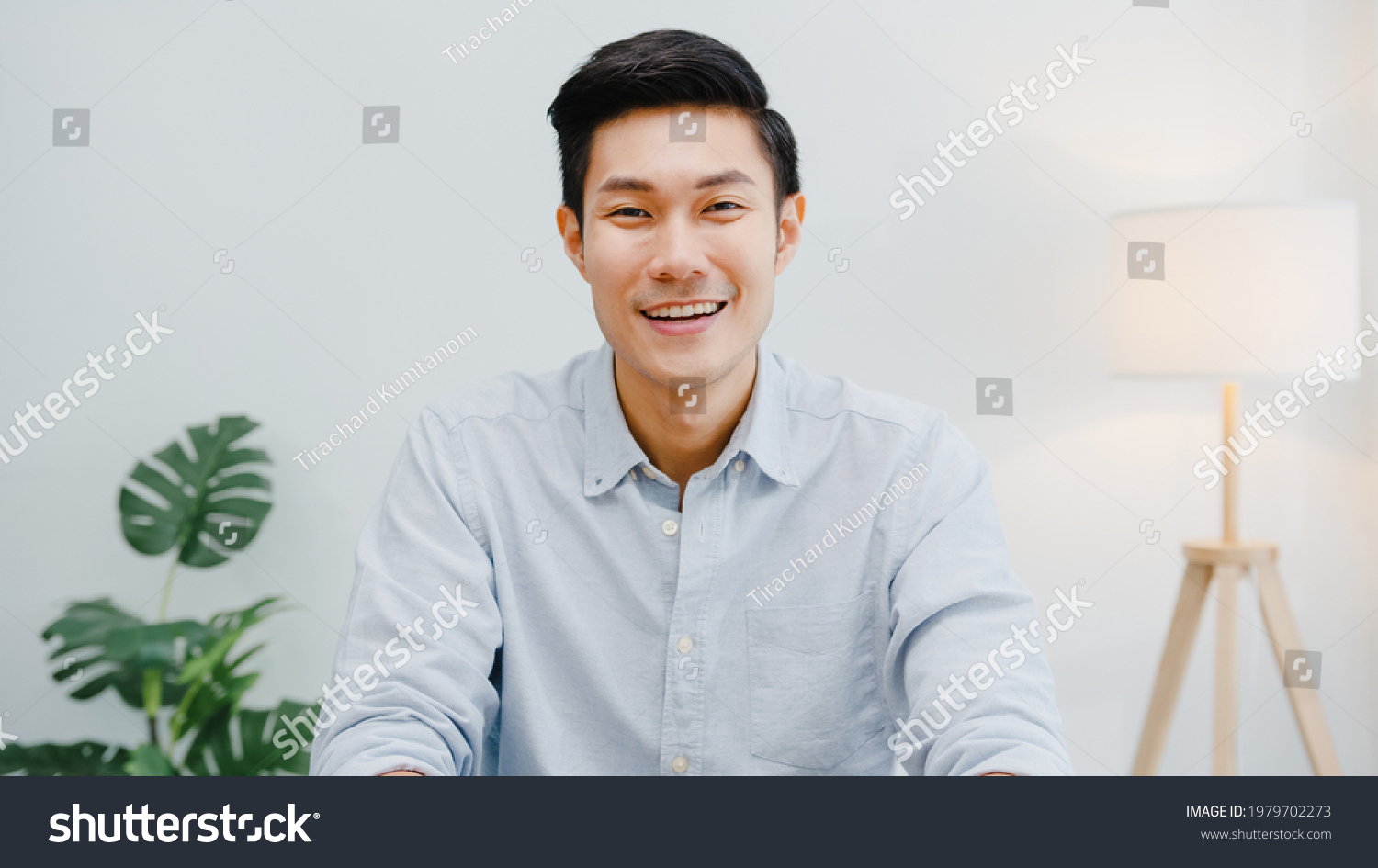 Portrait of successful handsome executive businessman smart casual wear looking at camera and smiling, happy in modern office workplace. Young Asia guy talk to colleague in video call meeting at home. #1979702273
