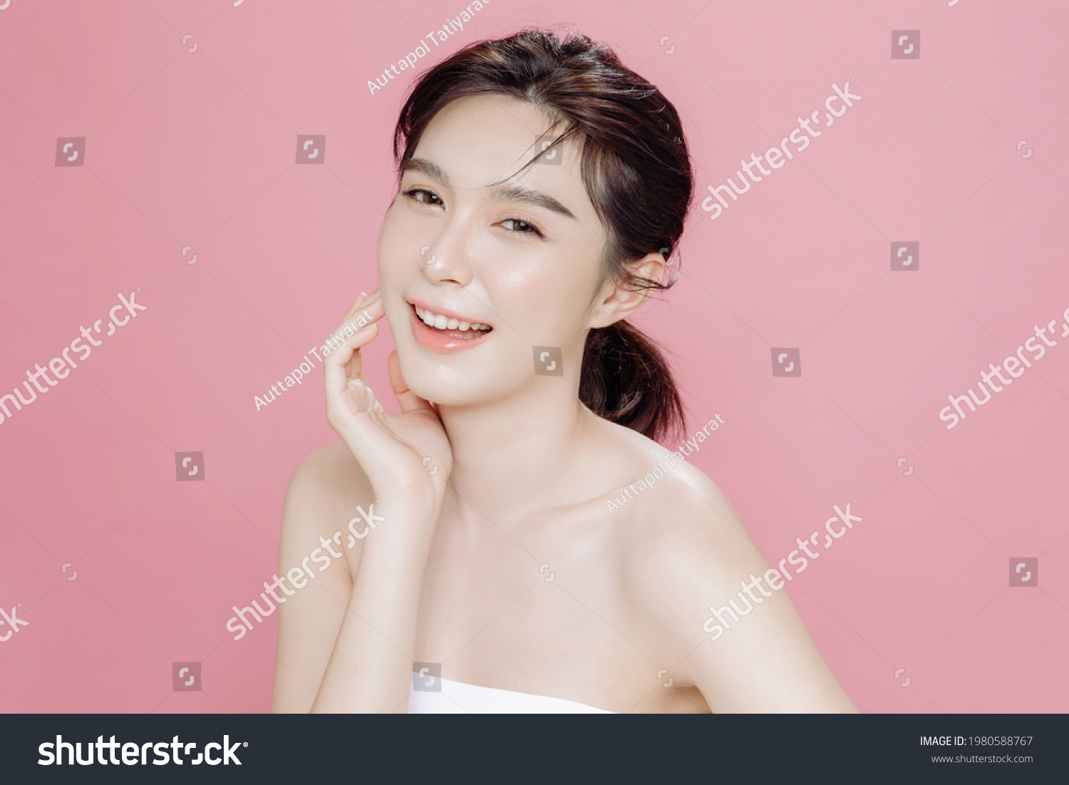 Asian woman has a lovely face is feeling happy with her perfect skin touch her face. She wears a white strapless bra. isolated over pink background. Skincare, cosmetology and plastic surgery concept. #1980588767
