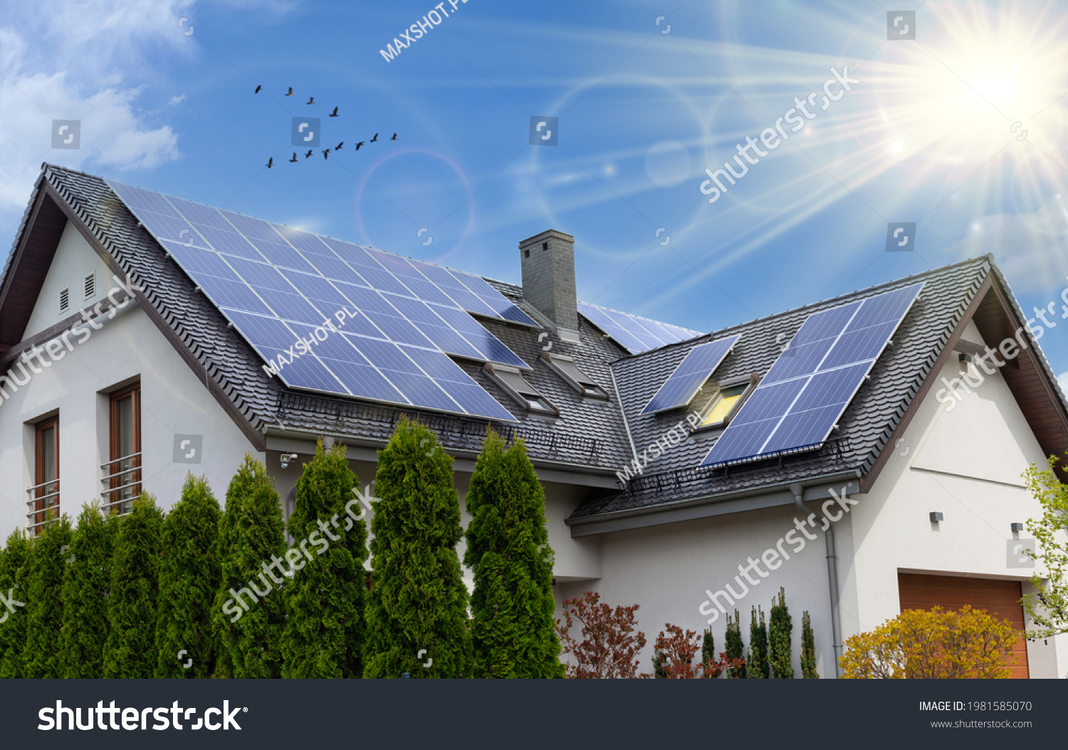Solar panels on a gable roof. Beautiful, large modern house and solar energy. Rays of the sun. #1981585070