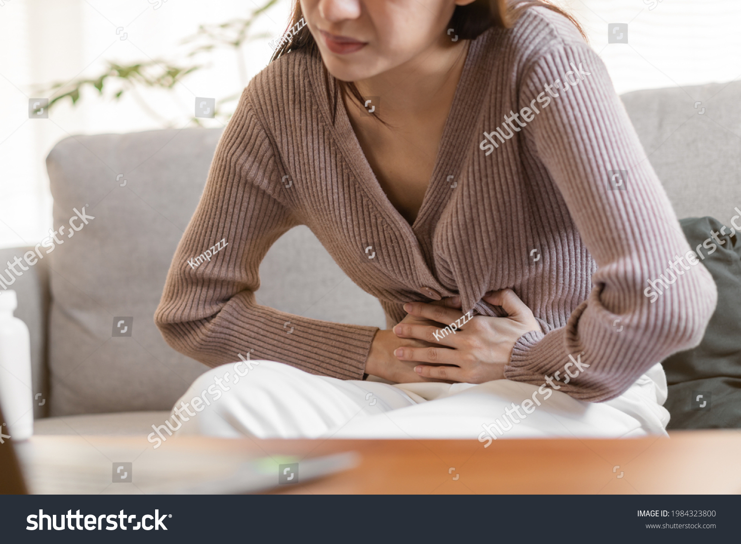 Flatulence young asian woman, girl hand in stomach ache, suffer from food poisoning, abdominal pain and colon problem, gastritis or diarrhoea. Patient belly, abdomen or inflammation, concept. #1984323800