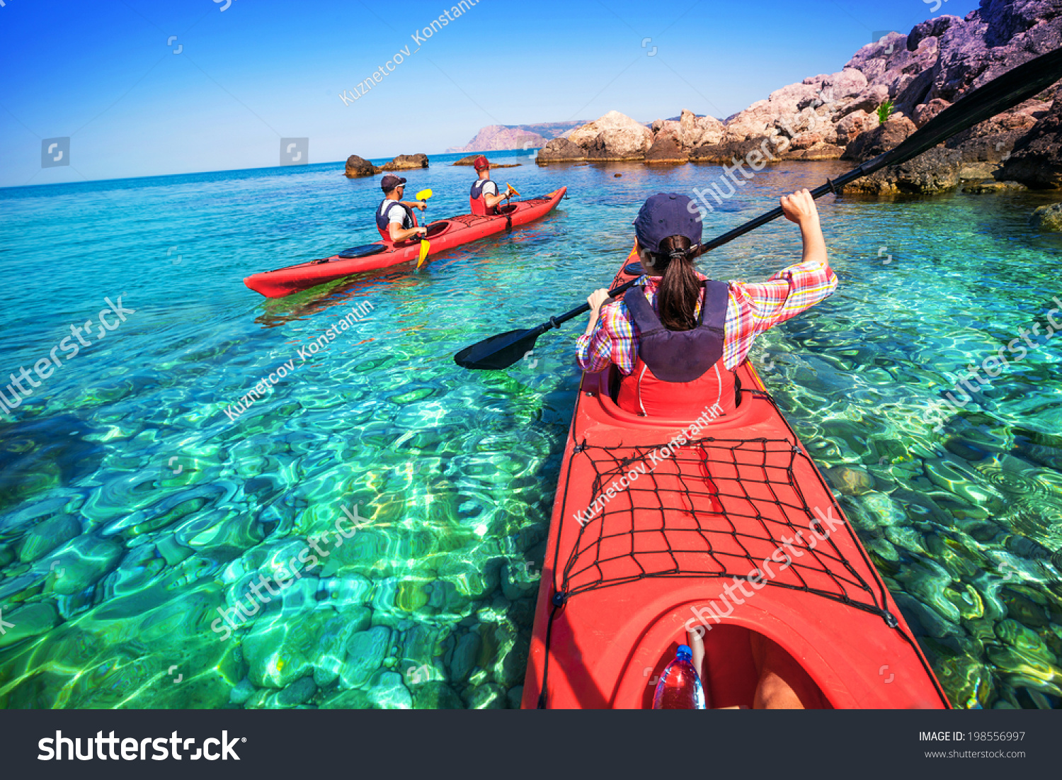 Two men paddle a kayak on the sea. Kayaking on island #198556997