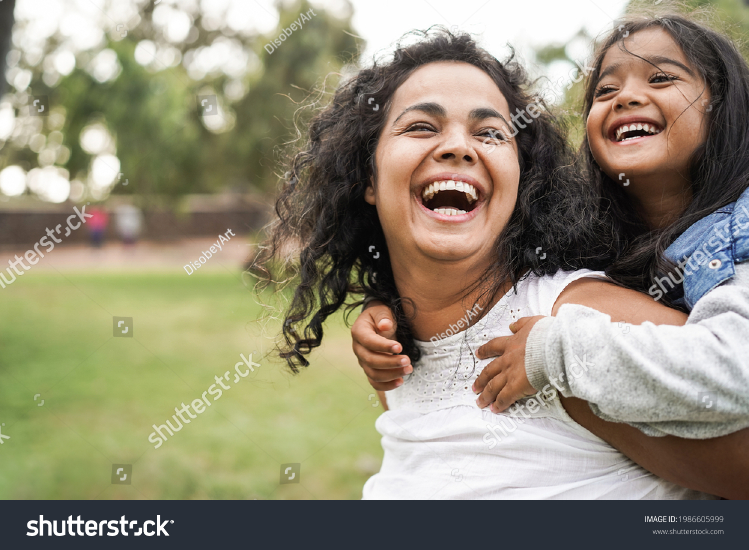 Happy indian mother having fun with her daughter outdoor - Family and love concept - Focus on mum face #1986605999