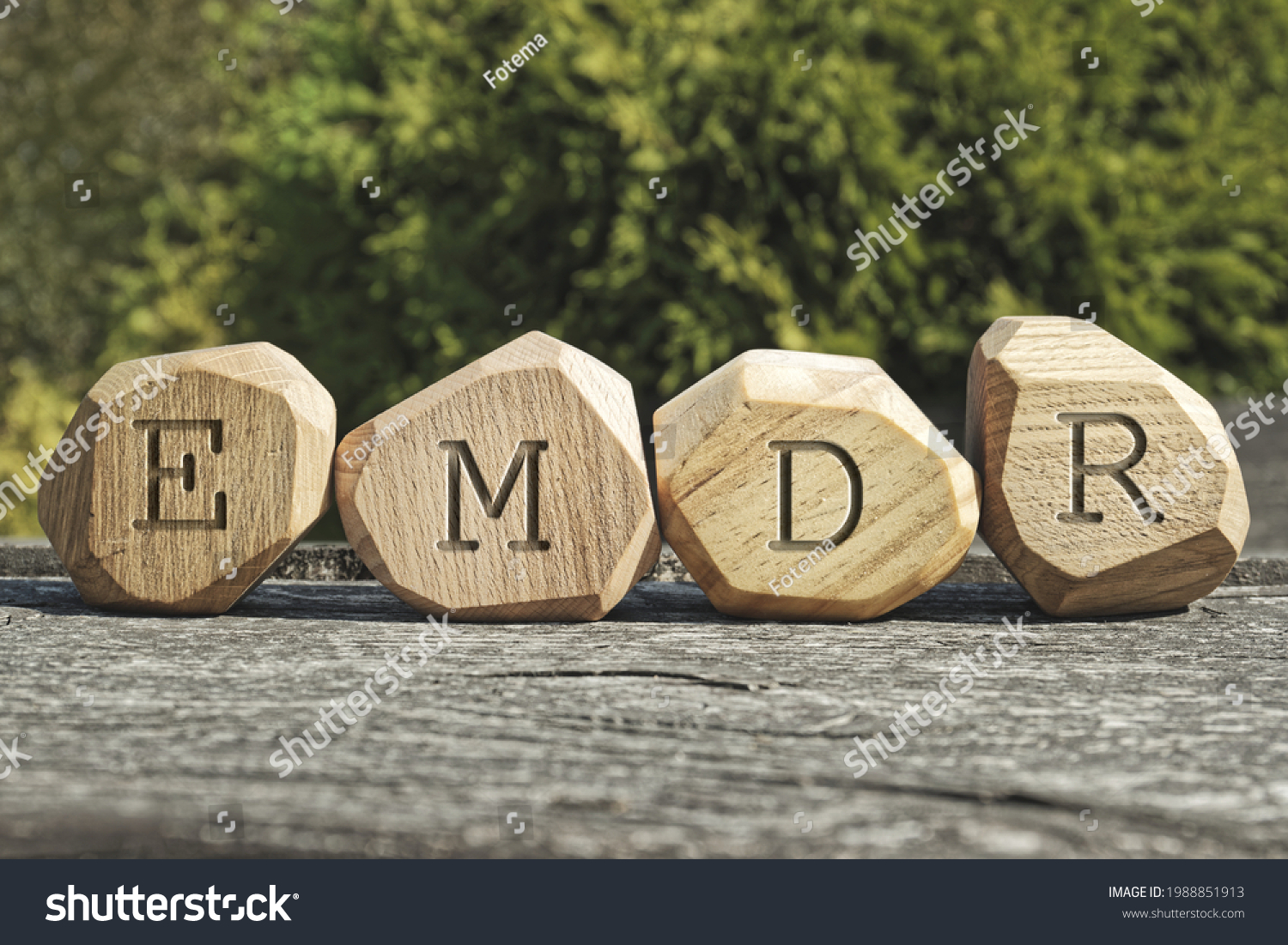 Letters EMDR written on wooden irregular blocks. Eye Movement Desensitization and Reprocessing psychotherapy treatment concept. #1988851913