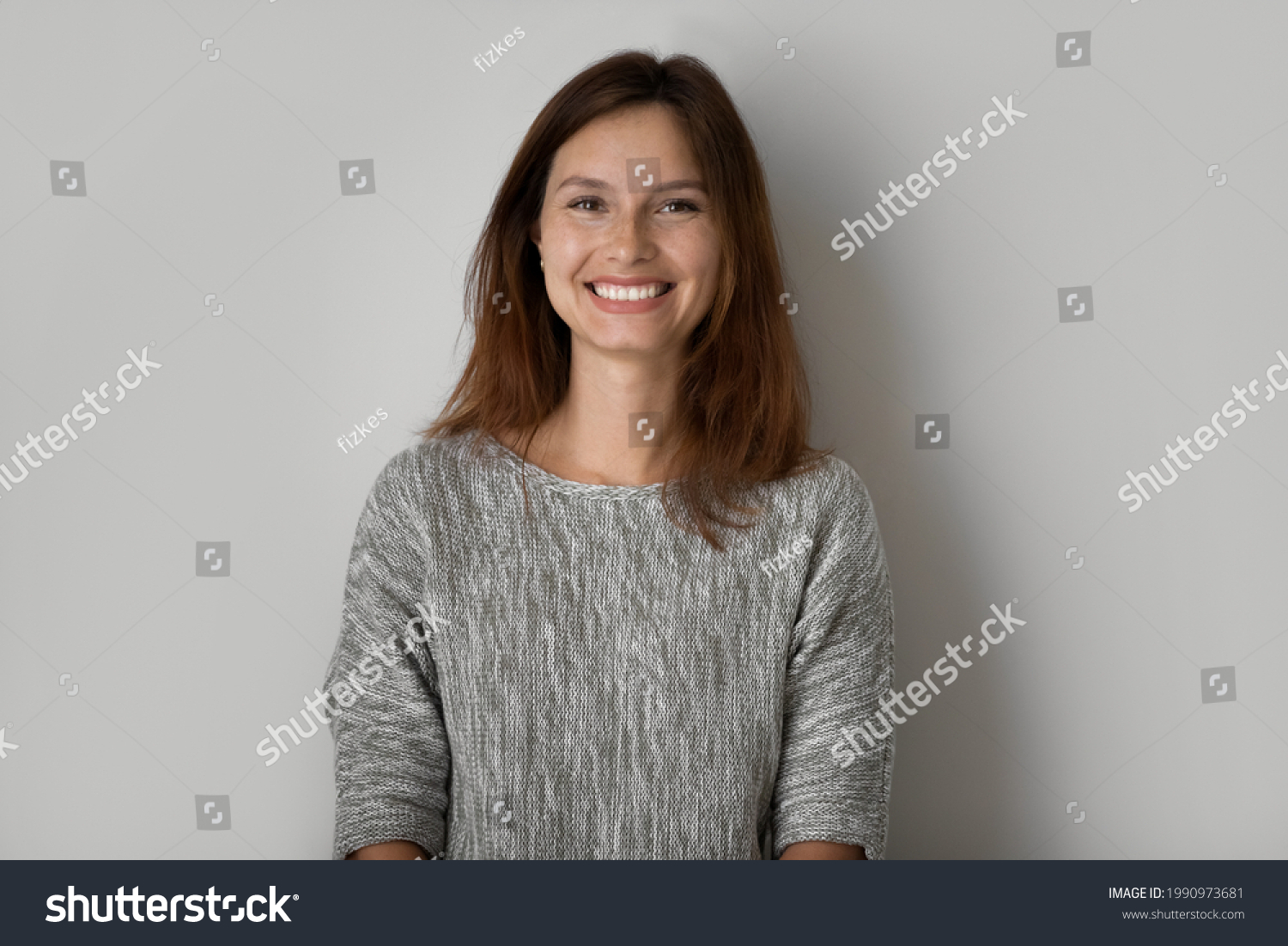 Head shot portrait of positive beautiful woman posing on grey studio background isolated, happy young female with healthy toothy smile and perfect smooth skin looking at camera, natural beauty #1990973681