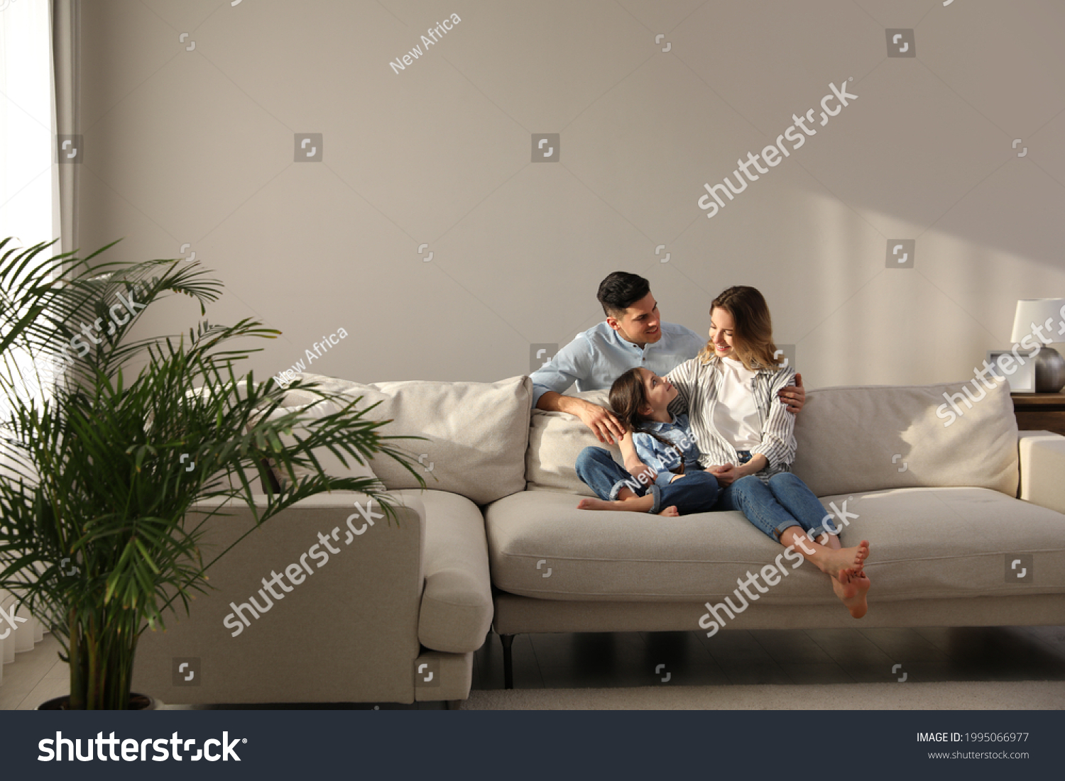 Family with little daughter resting on sofa in living room #1995066977